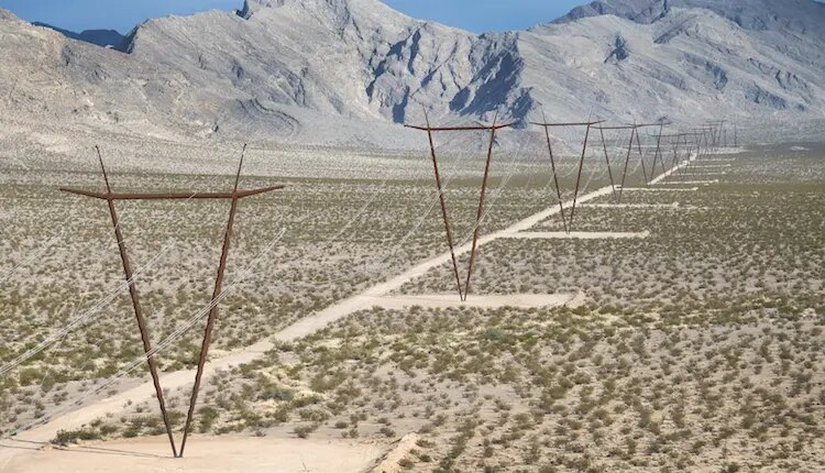 High-voltage transmission towers stretching across the Nevada landscape