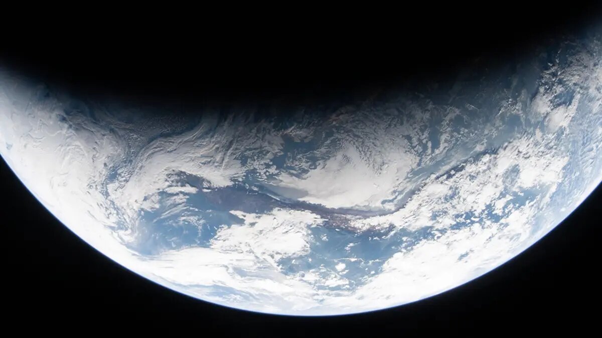 A sliver of Earth glowing against space as seen from NASA's Orion spacecraft