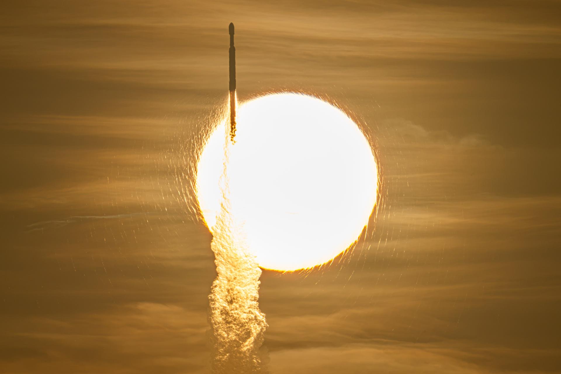 A SpaceX Falcon Heavy carrying NASA's Roman Space Telescope crosses in front of the Sun during launch